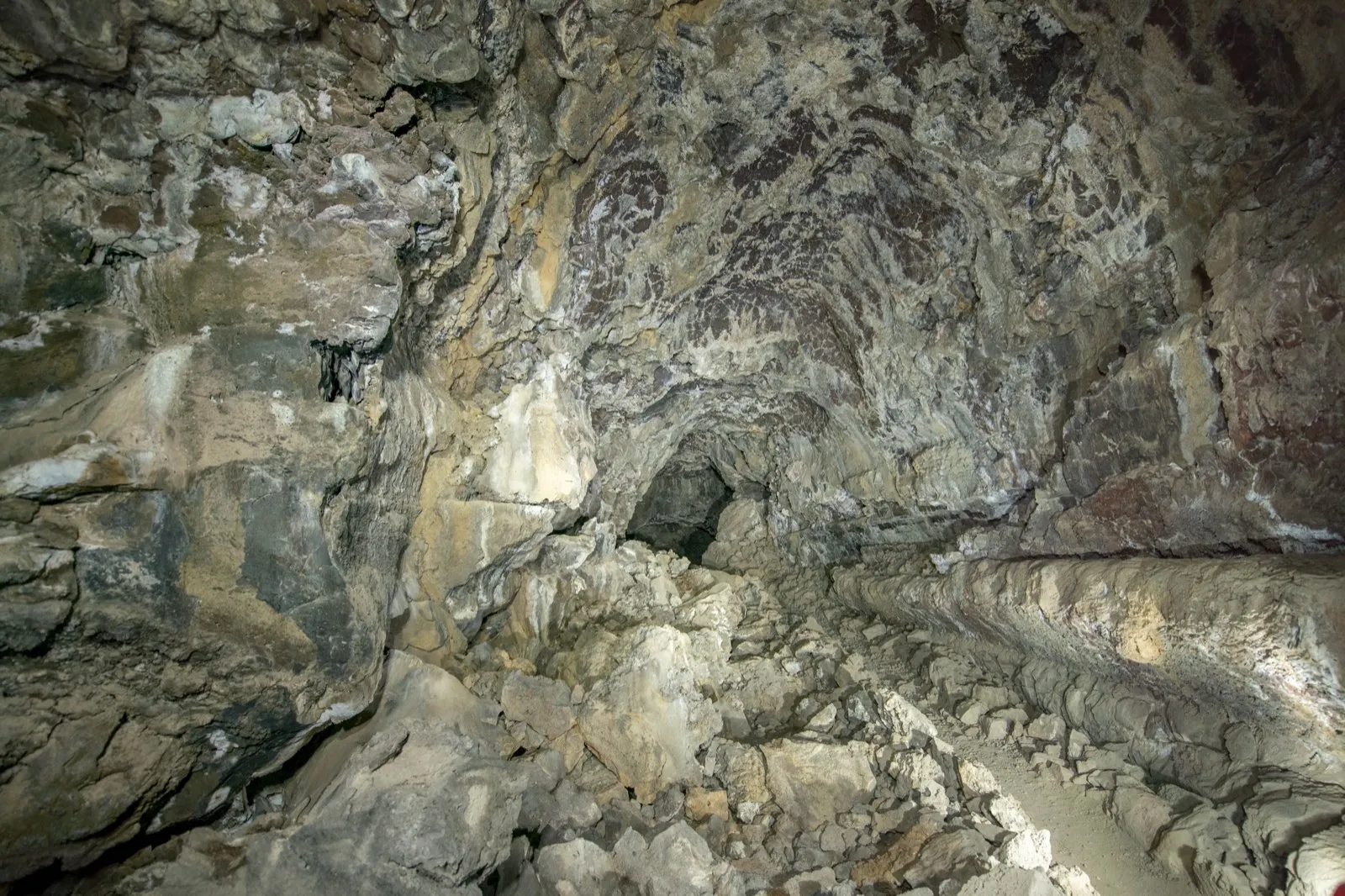The banded rock walls of Sentinel Cave, a lava tube at Lava Beds National Monument, lit by headlamp.
