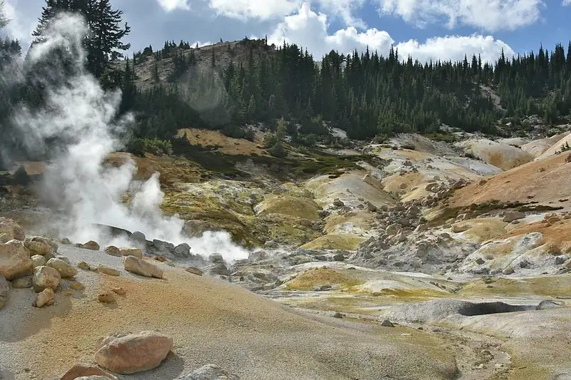 Steam rises from pale, muddy pools in the Bumpass Hell hydrothermal basin.