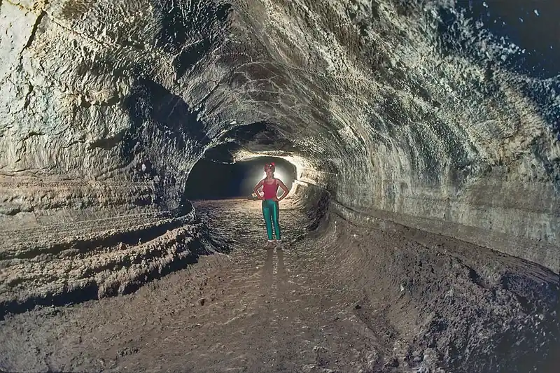 The inside of a lava tube at Lava Beds, where the dark rock walls close in around you.