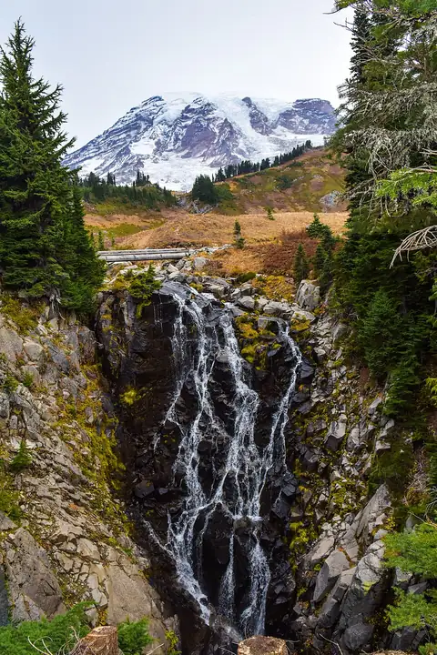Myrtle Falls cascading over rock with Mount Rainier rising behind it.