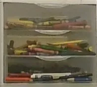 An assorted box of crayons photographed in an old schoolhouse.